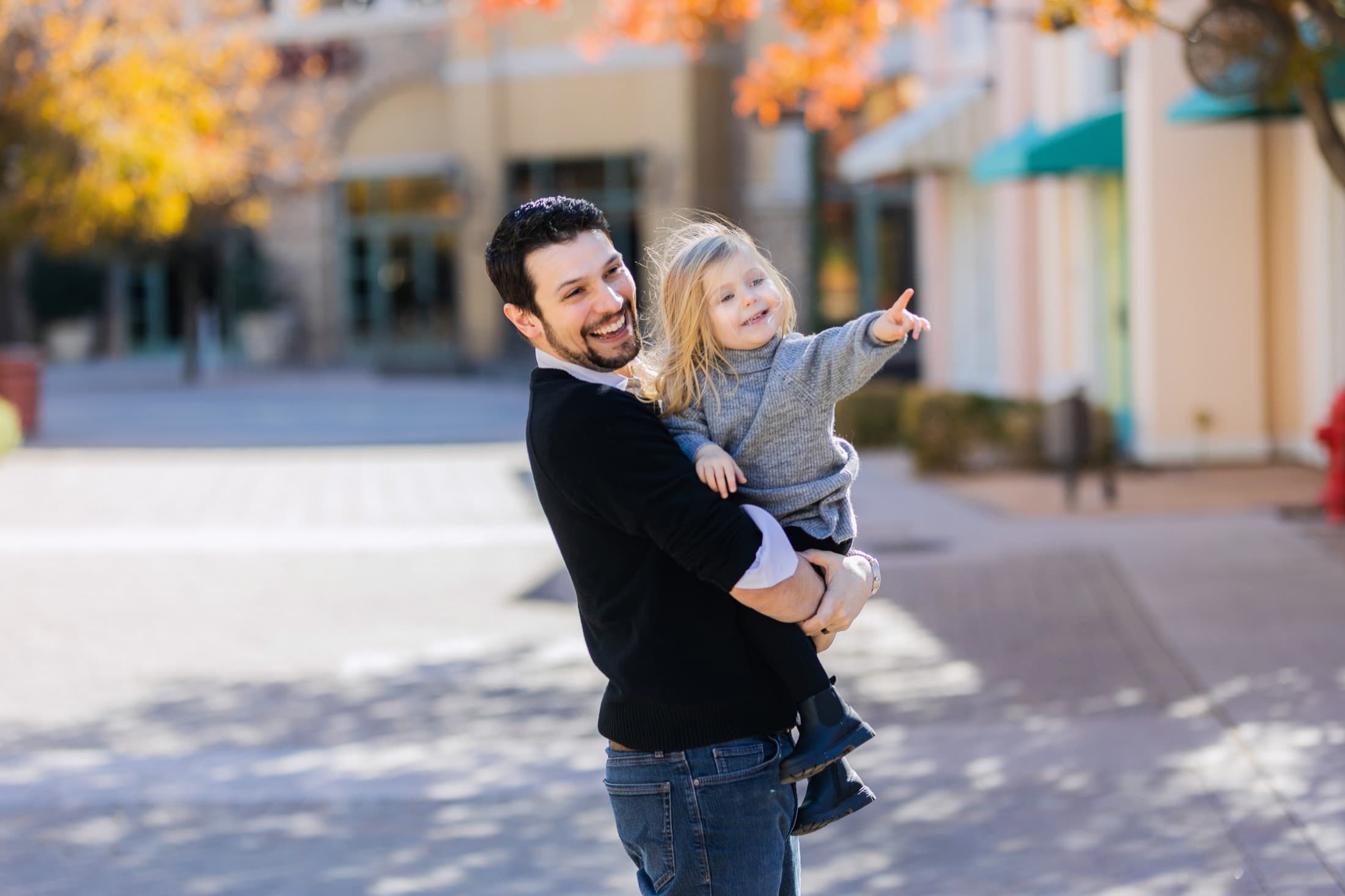 Anthony Ramirez holding his daughter outdoors.